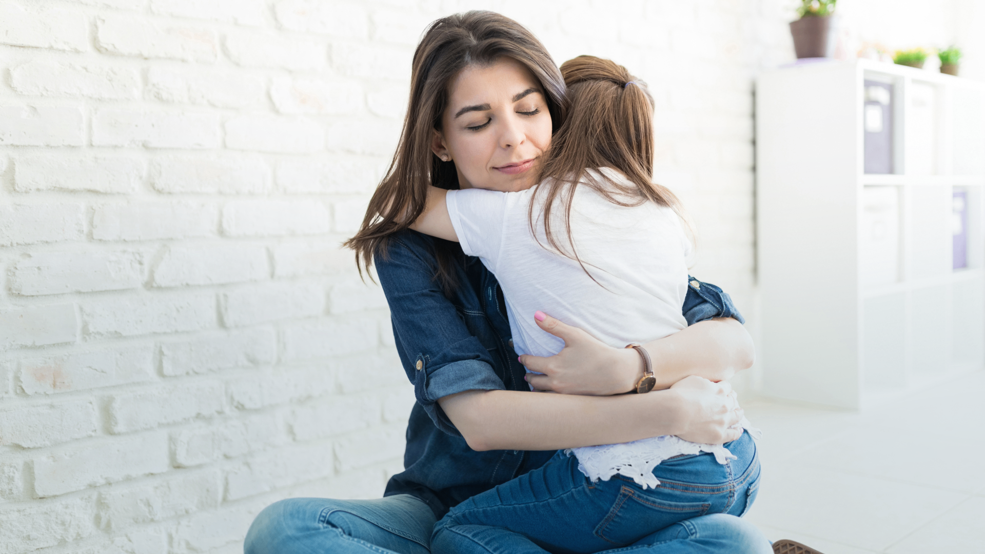 A mother hugging her daughter at home, representing peace of mind through home security.