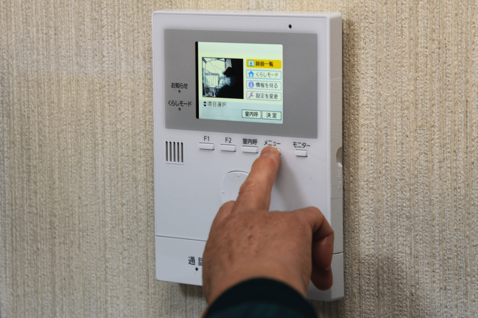 A close-up of a video intercom device mounted on a wall.